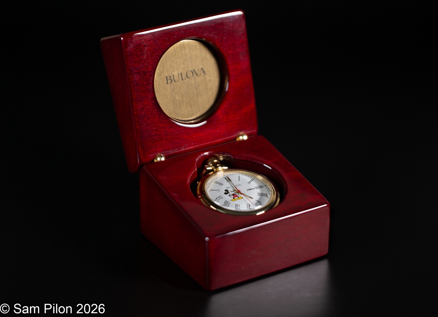 Macro product photograph of a Bulova pocket watch in a wooden presentation box